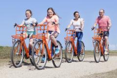 Familia en bicicleta por la costa de holanda