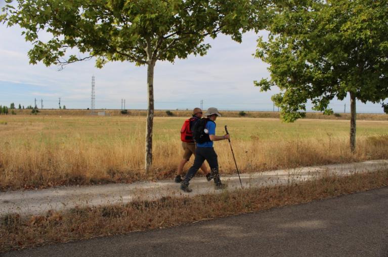 Peregrinos con discapacidad visual caminando por andadero 