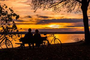 Ciclistas contemplando atardecer en el Lago Constanza