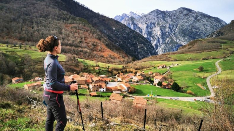 Hiker walking the Camino Lebaniego, staring at a village