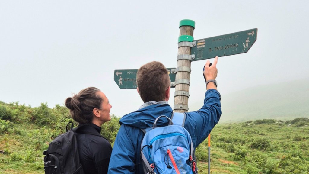 Pareja de senderistas delante de se&ntilde;al de ruta Terenosa / Urriellu