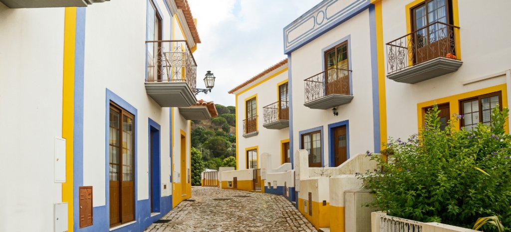 Calle de Carrapateira con casas pintadas de amarillo y azul
