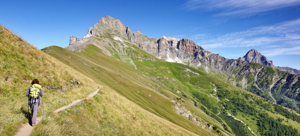 Senderista dirigiéndose a formaciones rocosas en Val Maira